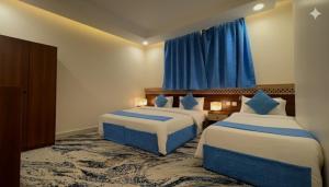 a hotel room with two beds and a window at فندق الروضة المتحدة Hotel AL Rawdah United in Al Khansāk