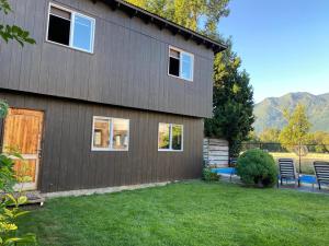a house with a grass yard in front of it at Hostal Tour Pucon in Pucón