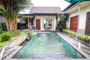 a swimming pool in front of a house at Villa JJ and Spa Ubud in Ubud