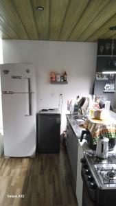 eine Küche mit einem weißen Kühlschrank und einem Herd in der Unterkunft Casa do Steve in Florianópolis