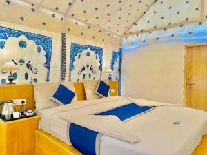 a bedroom with a large bed with blue and white decorations at Marwar Desert Camp Sam Jaisalmer in Sām +76 photos