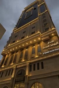 a tall building with lights on top of it at فندق الروضة المتحدة Hotel AL Rawdah United in Al Khansāk