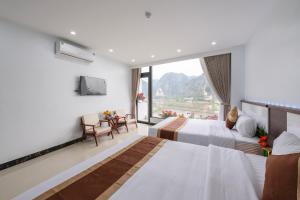 a hotel room with two beds and a window at Tam Coc Sunshine Villa in Vũ Lâm +58 photos