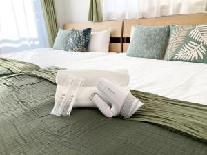a bed with two white towels on top of it at Neo Universal 05 in Wada