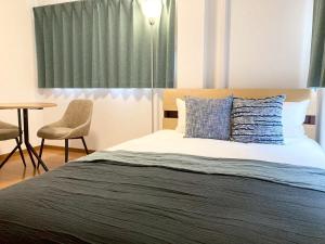 a bedroom with a bed with a table and a chair at Neo Universal 05 in Wada