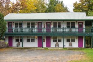 an old house with pink doors and a balcony at Lumber Jill Lodge in Balsam Lake