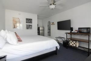 a bedroom with a white bed and a flat screen tv at Lumber Jill Lodge in Balsam Lake