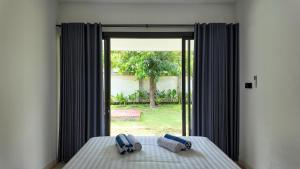 a bedroom with a bed with two towels and a window at Pulau Indah Lombok in Kuta Lombok