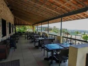 a restaurant with tables and chairs on a balcony at Flat para 6 pessoas no Condomínio Monte Castelo Mod 4 Flat 1B in Bezerros