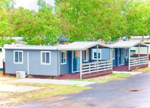 a blue house with a porch on a street at Macquarie Caravan Park in Warren