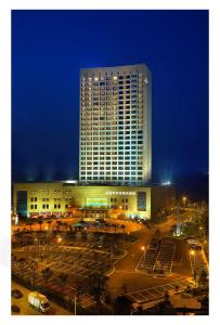 a large building with a parking lot in front of it at Jinhai New Century Grand Hotel Ninghai in Ninghai
