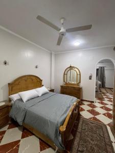a bedroom with a bed and a ceiling fan at Dahabiya Apartment in Luxor