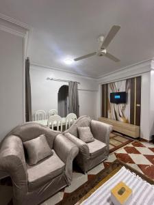 a living room with a couch and a ceiling fan at Dahabiya Apartment in Luxor