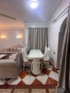 a living room with a table and chairs and a couch at Dahabiya Apartment in Luxor