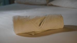 a towel sitting on top of a bed at Hotel Joia in Cascavel