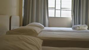 a white towel laying on a bed in a bedroom at Hotel Joia in Cascavel