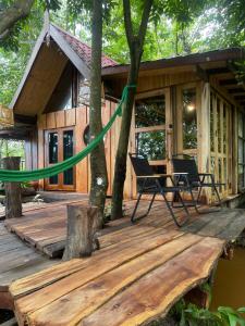 a wooden deck with a house with a green hose at Baancherda in Ban Nong Hu