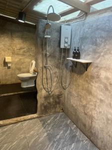 a bathroom with a shower and a toilet at Baancherda in Ban Nong Hu