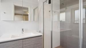 a white bathroom with a sink and a shower at Boater's Retreat - pet friendly, right off the M1 in Toormina +10 photos