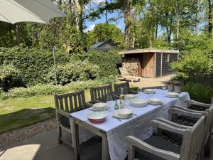a table with plates and glasses on it in a garden at Het Bosch in Bergen +5 photos