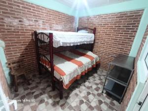a room with two bunk beds in a brick wall at Hiker's Home - Hostel Inn in Amecameca de Juárez