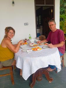 a man and woman sitting at a table eating food at Moonlit serenity Tangalle in Tangalle