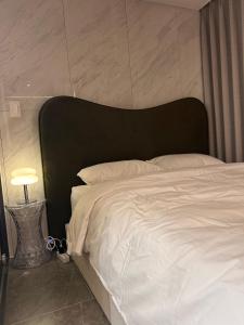 a bedroom with a white bed with a black headboard at 케이 코지 하우스 - 스튜디오 in Seoul