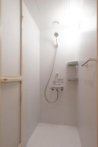 a shower in a bathroom with a glass door at ファーストキャビン松江 in Matsue