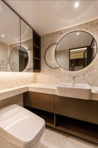 a bathroom with a toilet and a sink and a mirror at 케이 코지 하우스 - 스튜디오 in Seoul