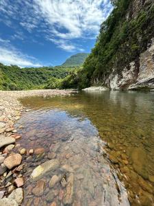a river in the mountains with rocks in the water at cabana Eco da Natureza in Praia Grande +6 photos