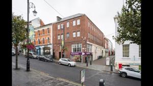 a city street with cars parked in front of buildings at ApartmentA in Derry Londonderry