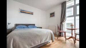 a bedroom with a bed and a table and a window at ApartmentA in Derry Londonderry