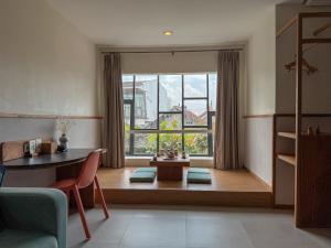 a living room with a table and a large window at YATS Colony in Yogyakarta