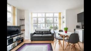 a living room with a black leather couch and a table at ApartmentA in Derry Londonderry