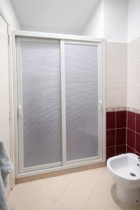 a bathroom with a sliding glass shower door at Spacious Family-Friendly Apartment in Temara