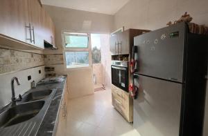a kitchen with a stainless steel refrigerator and a sink at Spacious Family-Friendly Apartment in Temara