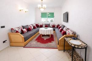 a living room with a couch and a table at Spacious Family-Friendly Apartment in Temara