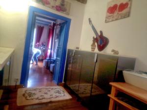 a person standing in a living room with a guitar on the wall at Appart Catalina La Mexicaine in Ucciani