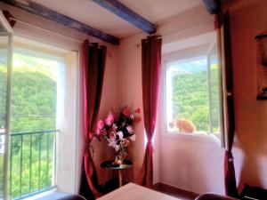 a vase of flowers sitting on a table next to a window at Appart Catalina La Mexicaine in Ucciani