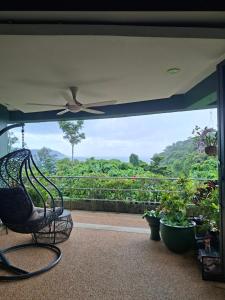 a porch with a rocking chair and plants at The Aspasia Kata Beach in Kata Beach
