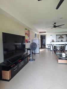 a living room with a large flat screen tv at The Aspasia Kata Beach in Kata Beach