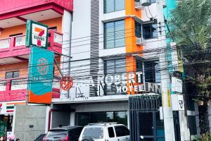 a street with cars parked in front of a building at Lea Robert Hotel Angeles City in Angeles