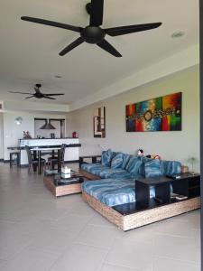 a living room with a couch and a ceiling fan at The Aspasia Kata Beach in Kata Beach