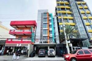 a tall building with cars parked in front of it at Lea Robert Hotel Angeles City in Angeles