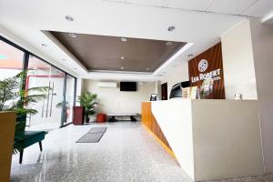 an office lobby with a reception desk and plants at Lea Robert Hotel Angeles City in Angeles +5 photos