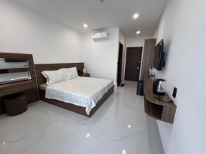 a bedroom with a bed and a television in it at H99 Homestay in Ðông Bình (2) +30 photos