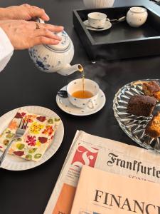 a woman pouring tea into a teapot with a cup of coffee at IGN Residence Colombo in Colombo +52 photos