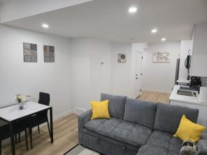 a living room with a couch and a table and a kitchen at Mayfair Suite in Airdrie