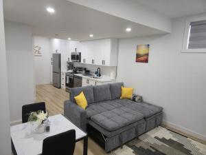 a living room with a couch and a table and a kitchen at Mayfair Suite in Airdrie +22 photos