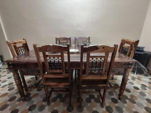a dining room table with six chairs and a wooden table at Prashaanti in Guwahati